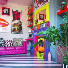 a brightly colored living room with pictures on the wall and colorful furniture in front of it