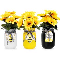 three mason jars with sunflowers in them are painted yellow and black, one has a bee on it