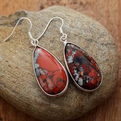 Like a small pebble hanging from the lobes of your ears, these superb dangling earrings in Natural Red Jasper will reveal their brilliant reflections. It is this specificity that makes the very beauty of this stone with such exceptional virtues. Red Jasper is known as the “supreme nurturer”. It sustains and supports through times of stress, and brings tranquility and wholeness. Jasper provides protection and absorbs negative energy. It balances yin and yang. Jasper clears electromagnetic and env Teardrop Jasper Jewelry With Natural Stones, Red Drop Gemstone Jewelry, Red Gemstone Drop Jewelry, Bohemian Red Gemstone Earrings, Red Teardrop Natural Stone Jewelry, Red Sterling Silver Earrings With Natural Stones, Red Jasper Jewelry With Natural Stones, Dangle Jasper Earrings With Ear Wire, Red Teardrop Gemstone Jewelry