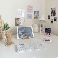 a tablet computer sitting on top of a white desk next to a keyboard and mouse