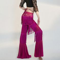 a woman in a black top and pink pants is standing with her hands on her hips