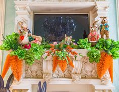 some fake carrots are on top of a fireplace mantel decorated with rabbits and flowers