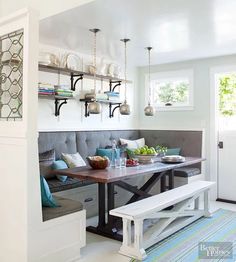 a kitchen with a bench, table and shelves on the wall next to an open door