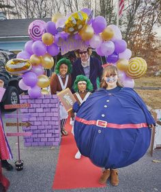 some people are dressed up and posing for a photo with balloons in the shape of an egg