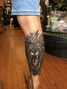 a man's leg with a tattoo on it and a lion head in the middle