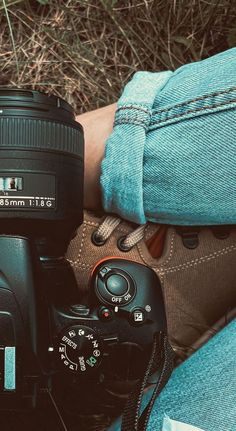 a person is holding a camera and taking a picture with it's lens on the ground