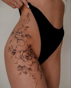 a woman's lower body with flowers on her stomach and the bottom half of her panties