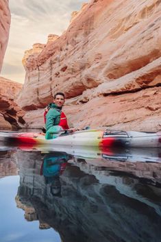 a man sitting on top of a kayak in the water