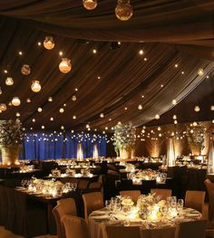 a banquet hall set up with tables, chairs and chandeliers for an event