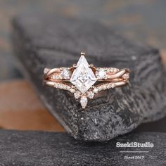 a black diamond ring sitting on top of a piece of rock with diamonds around it