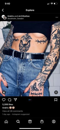 a woman with tattoos on her stomach and hands holding a cell phone in front of her