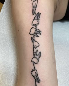 a black and white photo of a flower tattoo on the right arm, with many flowers coming out of it