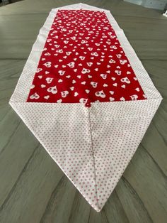 a red and white table runner with hearts on it