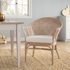 a wicker chair sitting in front of a table with a vase on top of it