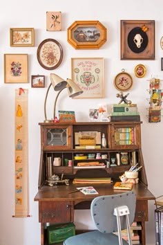 a desk with a chair and many pictures on the wall