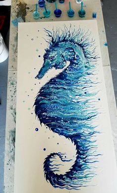 a drawing of a sea horse with blue paint on it's face and body