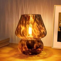 a lamp is sitting on a table next to a framed photo and an empty frame