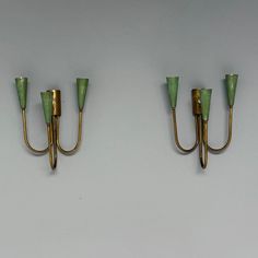 two green glass wall lights mounted to the side of a wall next to each other