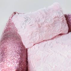 a pink teddy bear with sequins on it's back and pillow case