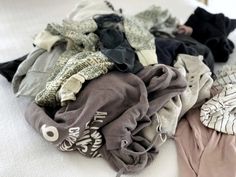 a pile of clothes sitting on top of a bed