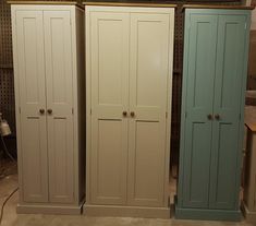 three tall white and blue cupboards in a room