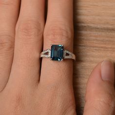 It is a London blue topaz ring. The main stone is 7 mm*9 mm emerald cut.weight about 3.26 carats. The basic metal is sterling silver and plated with rhodium. To change the metal to a solid gold (white/rose) or platinum is also available, please ask for a quotation if you want. You can also go to my shop Home for more elegant rings: https://www.etsy.com/shop/godjewelry?ref=hdr_shop_menu London blue topaz is November birthstone More London blue topaz rings: https://www.etsy.com/shop/godjewelry?ref Elegant Emerald-cut Topaz Rings, Elegant Topaz Rings With Rectangular Stone, Elegant Octagon Topaz Promise Ring, Elegant Rectangular Topaz Promise Ring, Elegant Topaz Ring With Baguette Cut, Classic Emerald-cut Topaz Ring In Sterling Silver, Elegant Baguette Cut Topaz Ring, Rectangular Topaz Ring For Anniversary, Fine Jewelry Topaz Ring With Rectangular Accent Stones