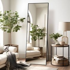 a mirror sitting on top of a wooden floor next to a white couch and table