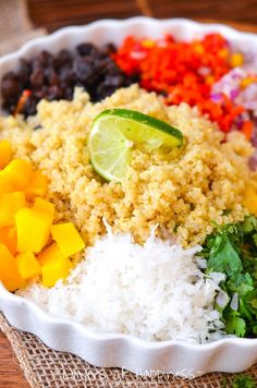 a bowl filled with rice, beans, and lime wedges on top of a table