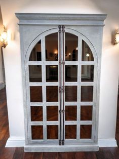 an arched glass door with wood flooring and white walls in a house or home