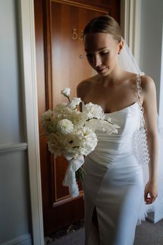 a woman in a wedding dress holding a bouquet of flowers