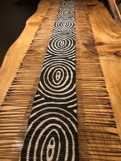 a wooden table topped with lots of black and white designs on it's sides