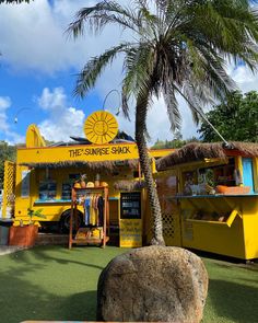 a yellow truck parked next to a palm tree in front of a building with a sign that says the sunrise shack