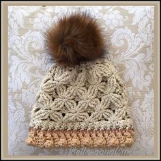 a crocheted hat with a brown pom - pom