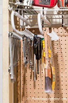 tools are hanging on the pegboard in this garage storage area, which is organized and organized