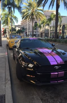 two cars are parked on the side of the street with purple stripes painted on them