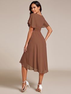 a woman is wearing a brown dress and high heeled shoes with her hands on her hips