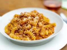 a white bowl filled with macaroni and cheese on top of a wooden table