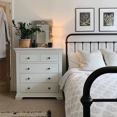 a bedroom with a bed, dresser and pictures on the wall next to each other