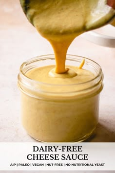 a jar filled with cheese sauce being drizzled over it's side