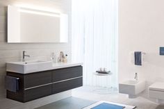 a bathroom with a sink, mirror and towel rack in it's center area