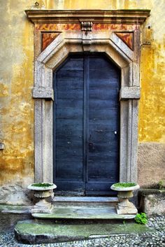 an old door with two planters in front of it