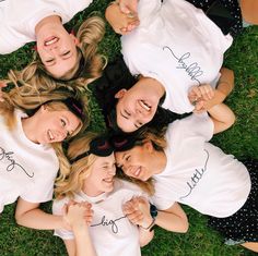 a group of young women standing next to each other on top of a grass covered field