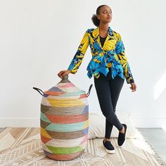 a woman standing next to a colorful round basket