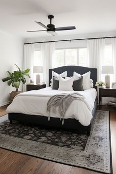 a bedroom with a bed, rug and ceiling fan