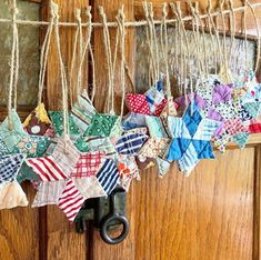 an old pair of scissors is hanging from a door with colorful fabric stars on it