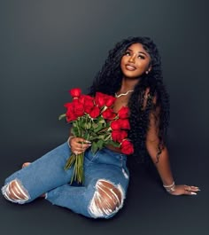 a woman sitting on the floor with roses in her lap