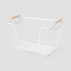 a white wire basket with wooden handles