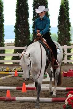 a woman riding on the back of a white horse