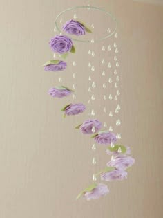 purple flowers are hanging from the ceiling with beads and water droplets on them, along with pearls