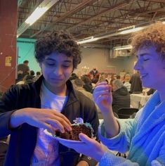 two people are eating cake at an event